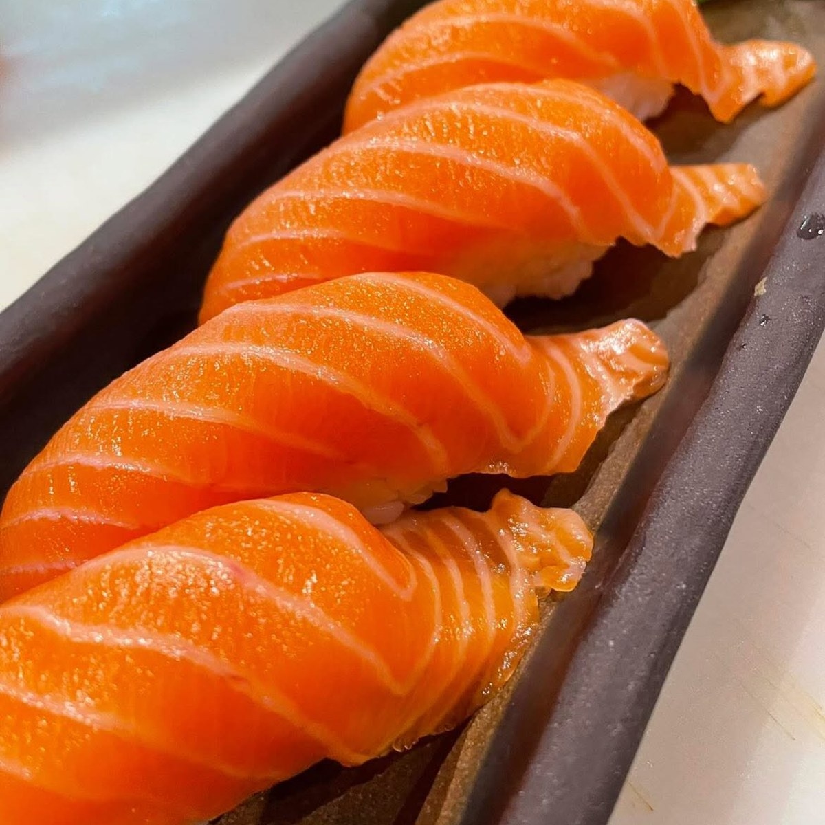 Nigiri di salmone serviti su vassoio in un ristorante sushi