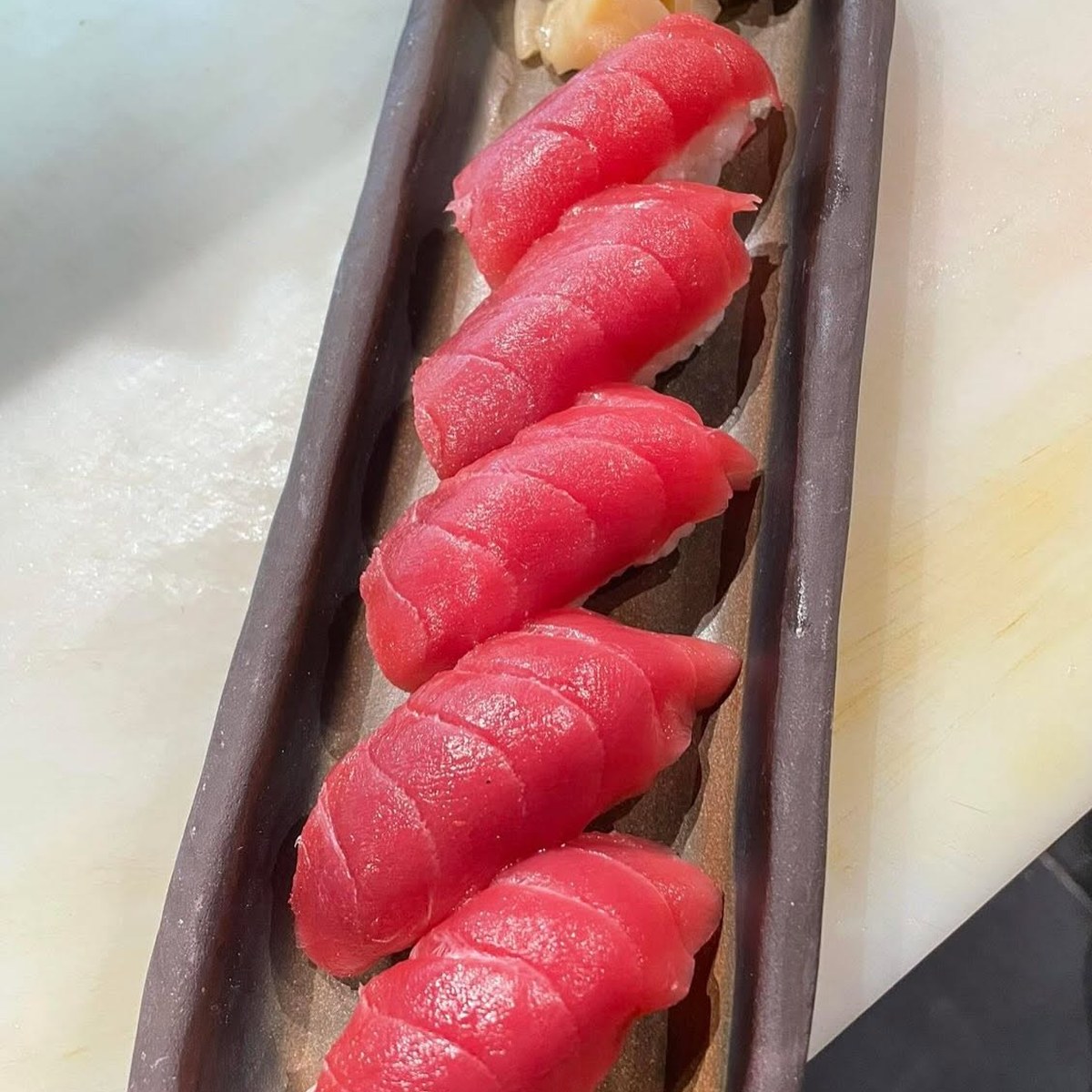 Sashimi di tonno fresco impiattato su vassoio scuro