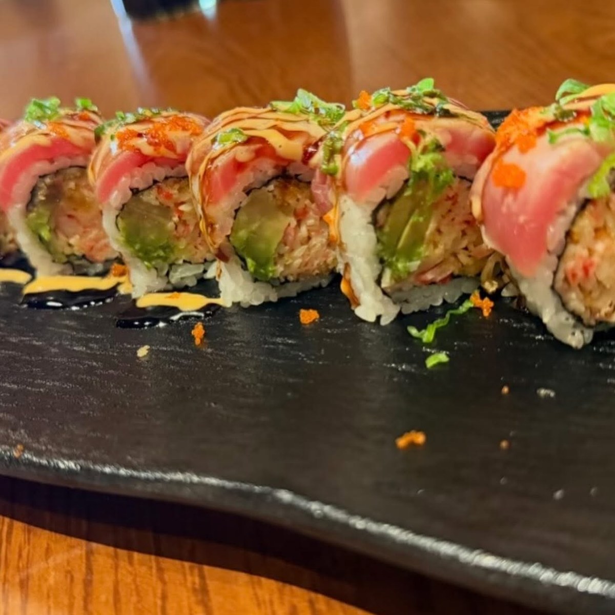Uramaki gourmet con topping di pesce e salse